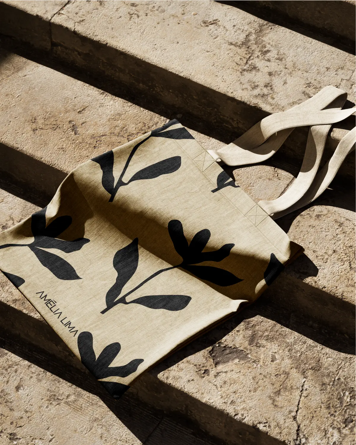 Ecobag com estampa de folhas pretas sobre degraus de pedra.