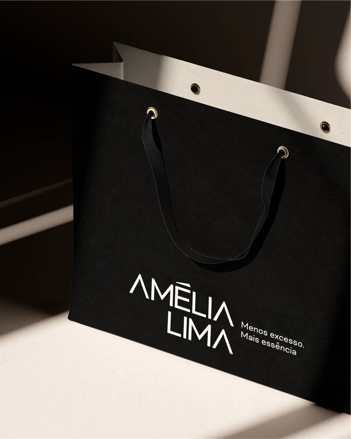 Sacola preta com o logo de Amélia Lima em branco.