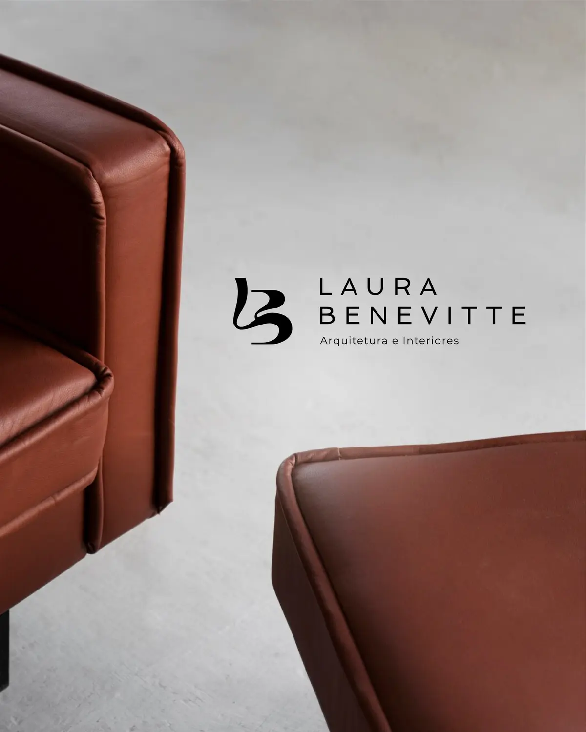 Logo de Laura Benevitte em parede cinza, ao lado de uma poltrona de couro.