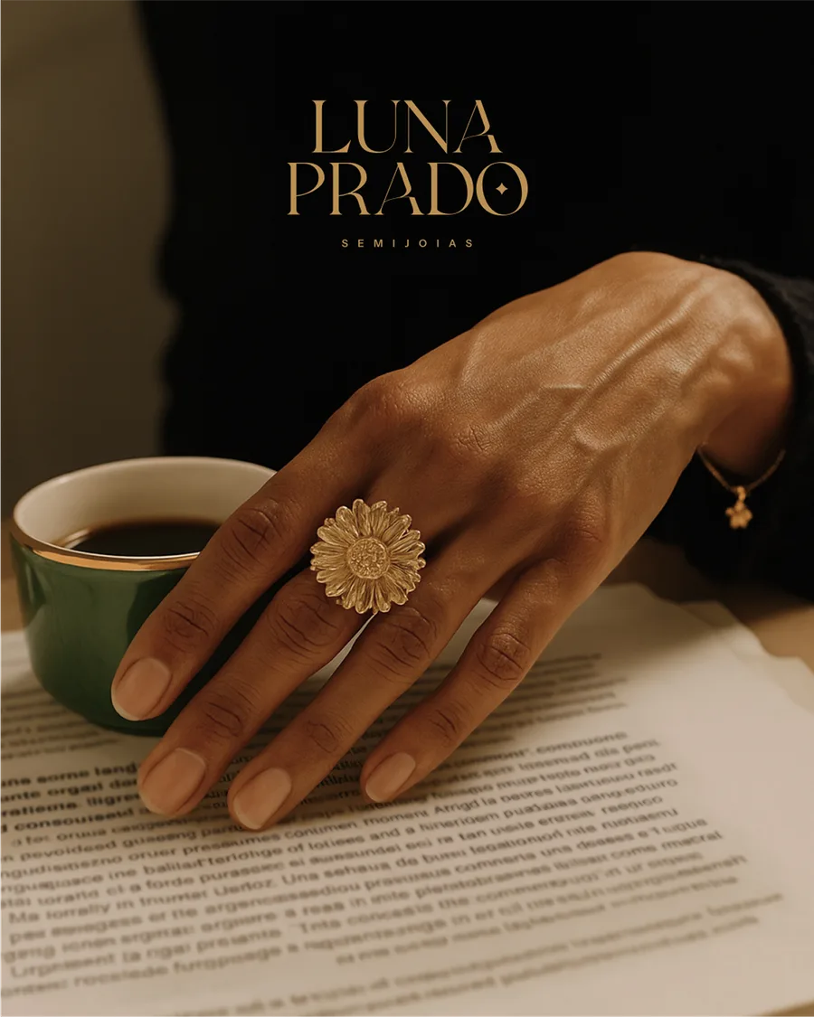 Mão com anel dourado ao lado de uma xícara de café, com o logo de Luna Prado acima.