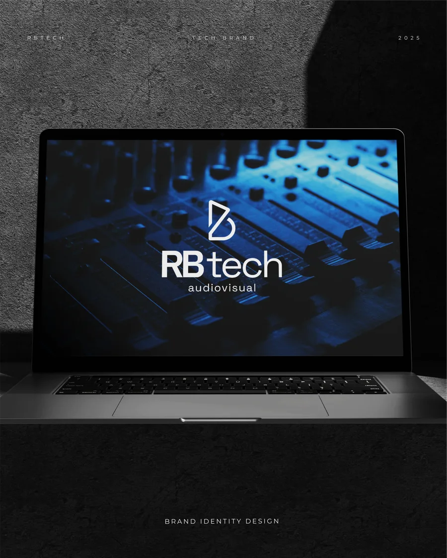 Notebook sobre mesa de som em ambiente escuro, com o logo da RB Tech na tela.
