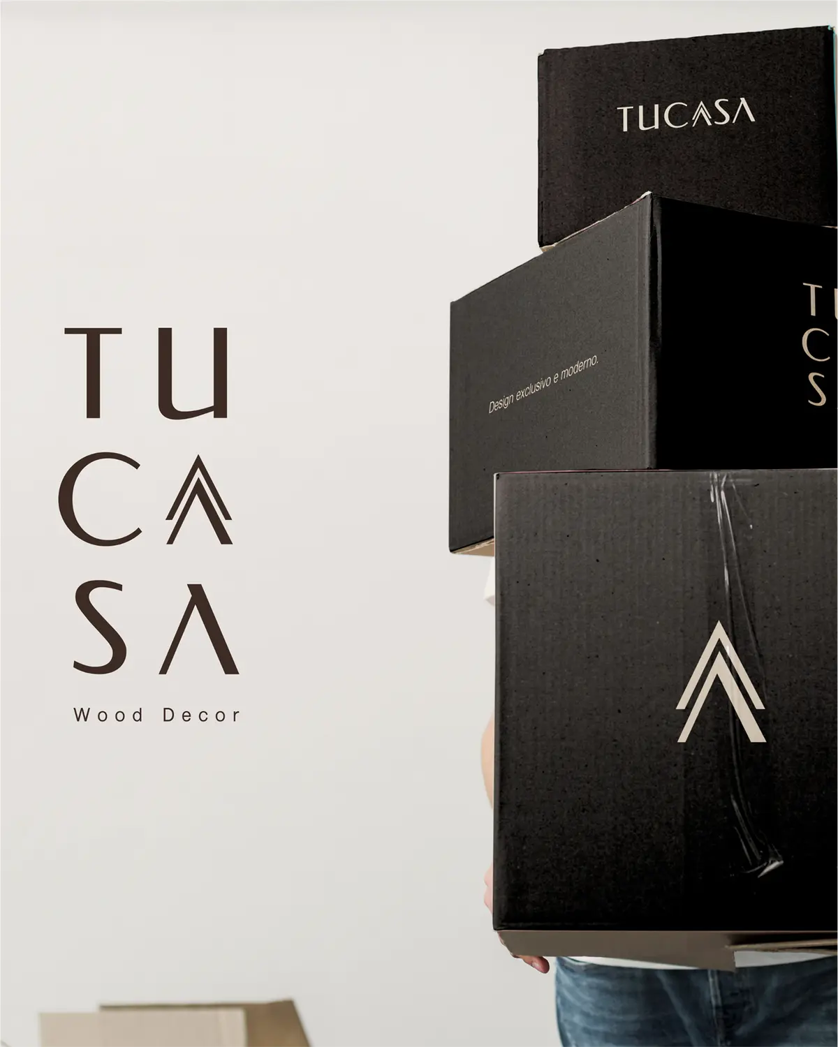 Pessoa segurando caixas pretas com o logo da TuCasa, ao lado do nome em marrom.